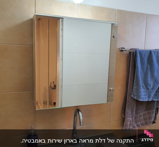 מראה זכוכית מעל כיור בחדר אמבטיה